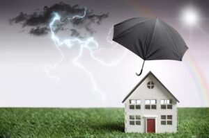 Wohngebäudeversicherung, Haus welches von einem Schirm geschützt ist